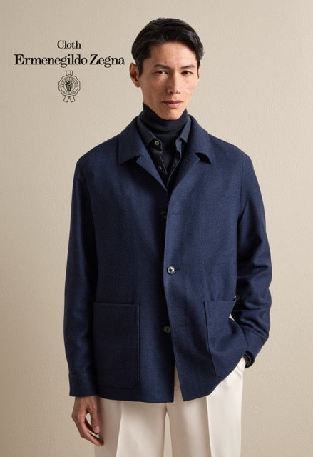 Model wearing a navy overshirt over dark knitwear with cream trousers; Ermenegildo Zegna cloth reference 67037.