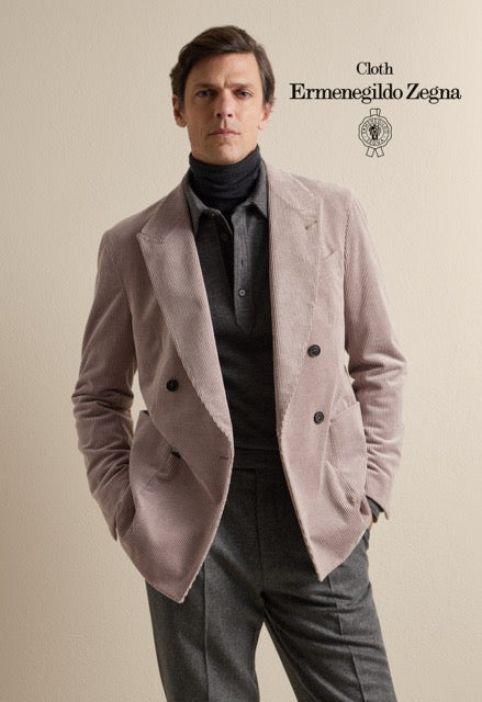 Model wearing a pale pink double-breasted jacket over dark knitwear and grey trousers; Ermenegildo Zegna cloth reference 67049.