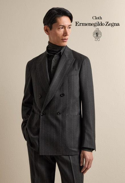 Model wearing a charcoal pinstripe double-breasted suit over dark knitwear; Ermenegildo Zegna cloth reference 67082.