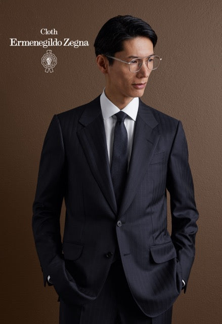 Model wearing a navy pinstripe suit, white shirt and navy tie; Ermenegildo Zegna cloth reference 67089.
