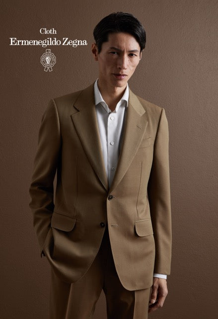 Model wearing a tan single-breasted suit over a white shirt; Ermenegildo Zegna cloth reference 67096.