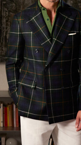 Navy double-breasted sport coat crafted from Ariston Italian fabric with a bold windowpane pattern, styled with a green polo for sophisticated modern tailoring.