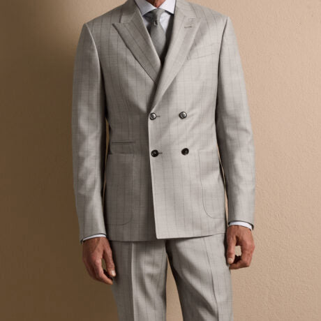 Close-up of a light gray double-breasted suit crafted from Ermenegildo Zegna Italian fabric, highlighting refined tailoring, subtle windowpane pattern, and classic peak lapels.