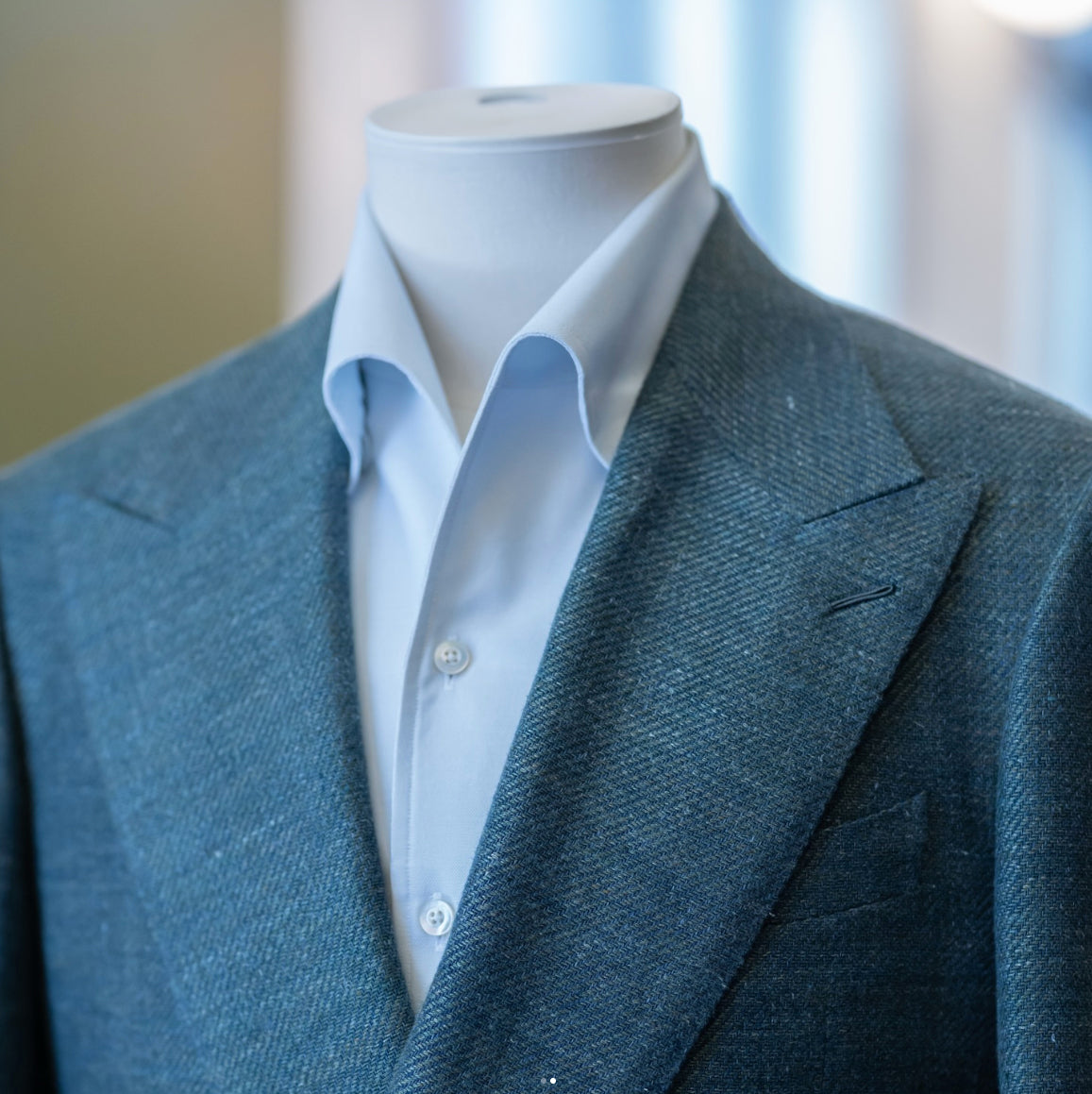 Close-up of a blue textured sport coat crafted from Lanificio Cerruti Italian fabric, paired with a light blue dress shirt to showcase refined tailoring and premium fabric texture.
