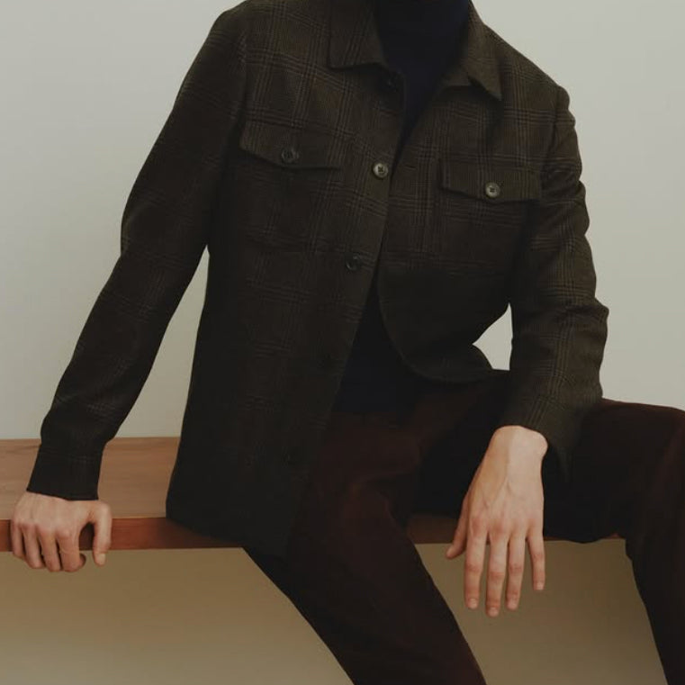 Dark brown plaid overshirt crafted from Dormeuil luxury fabric, layered over a black knit turtleneck for a sophisticated casual look.