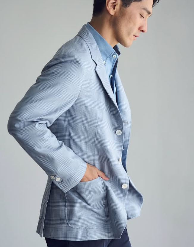 Light blue checked suit worn with an open-collar blue shirt.