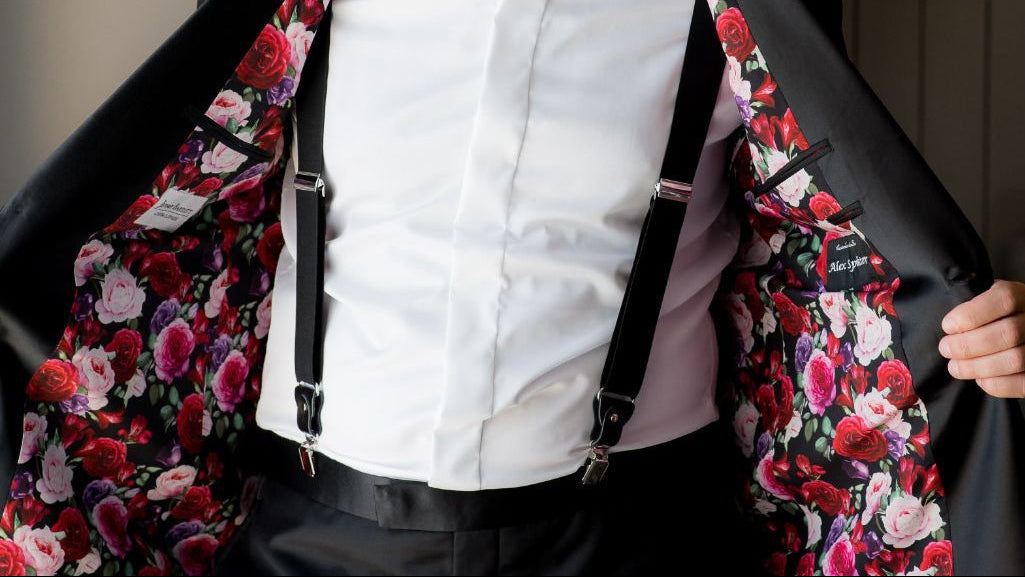 Custom tuxedo jacket by Jeffrey Bartlett Clothiers featuring a personalized floral lining, custom name embroidery, and black suspenders.