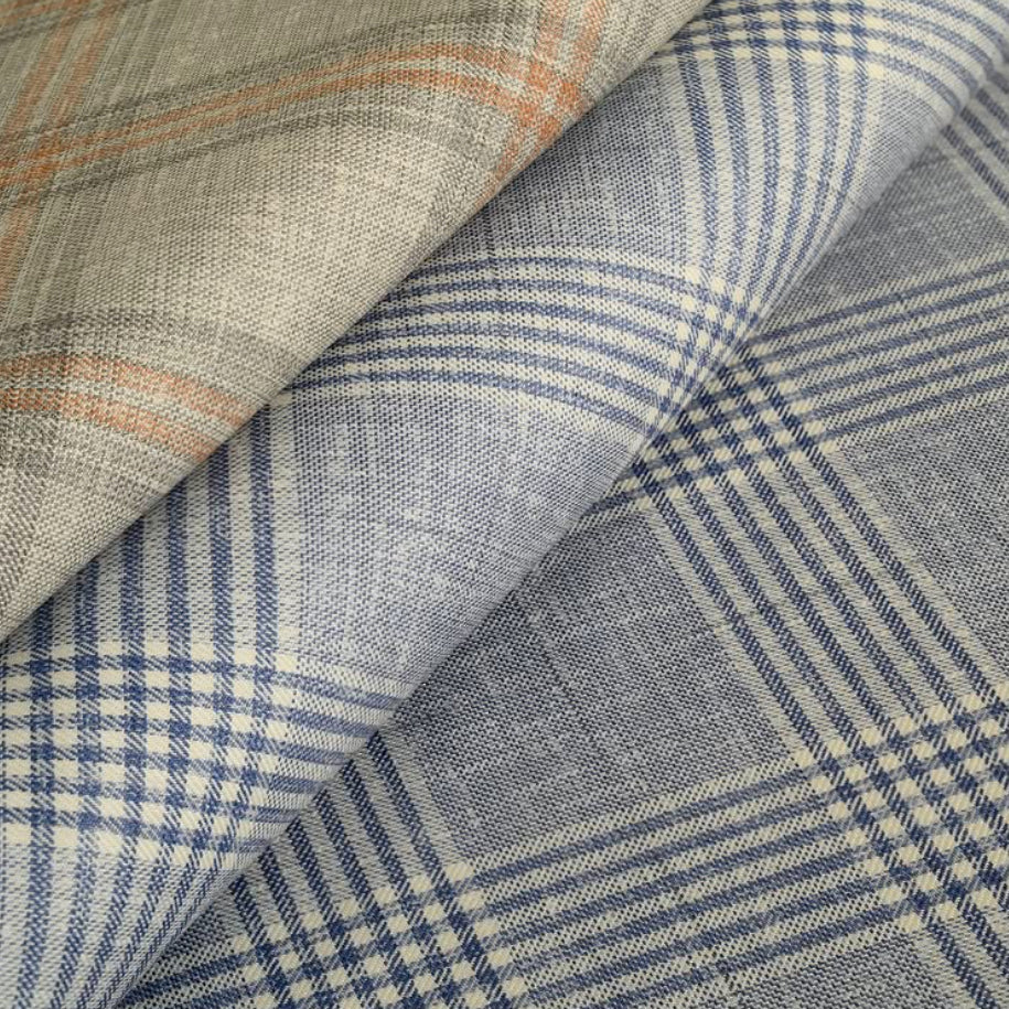 Layered Vitale Barberis Canonico wool fabrics featuring blue and beige plaid designs that highlight the mill's exceptional Italian craftsmanship and elegant fabric textures.